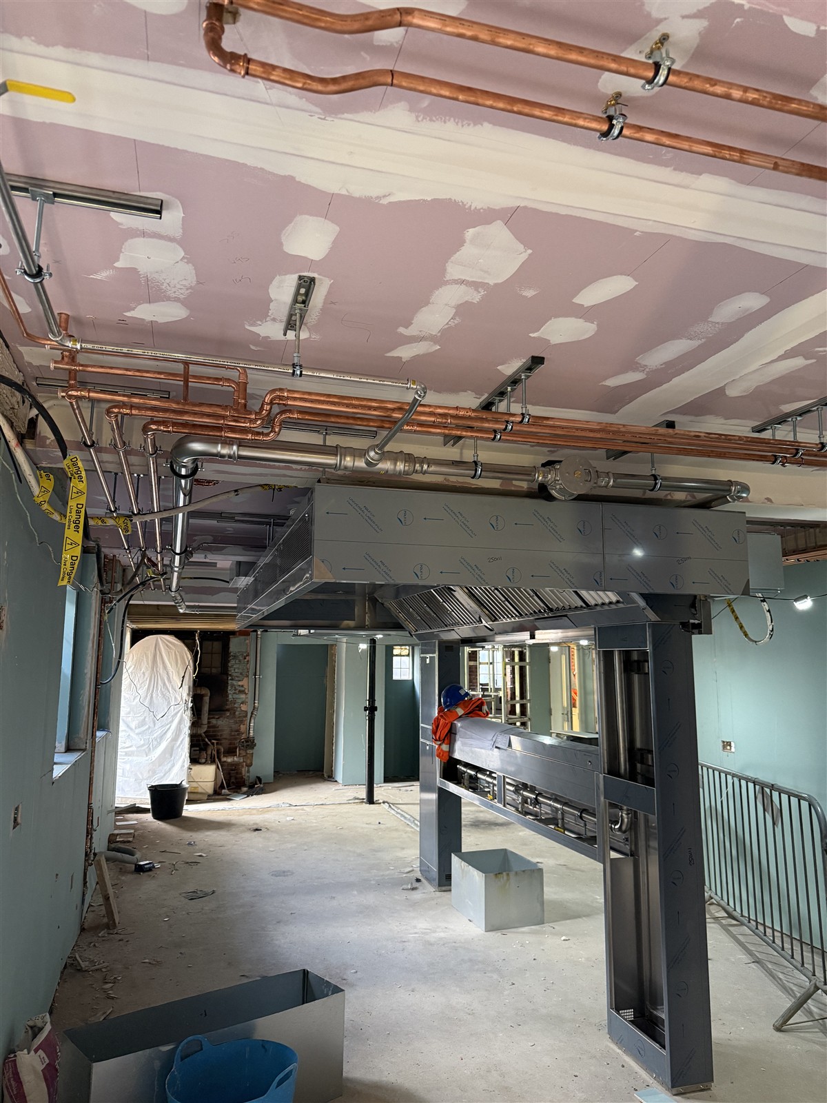 Overhead copper pipework across the unfinished kitchen ceiling at Beaconsfield Golf Club