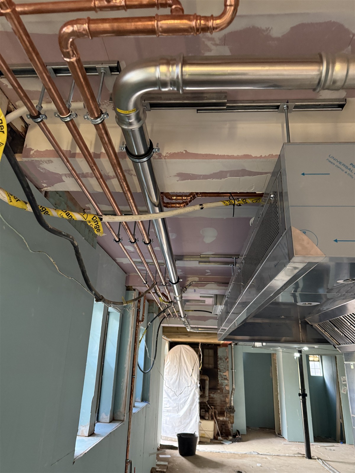 Copper and metal service runs above the kitchen during fit-out