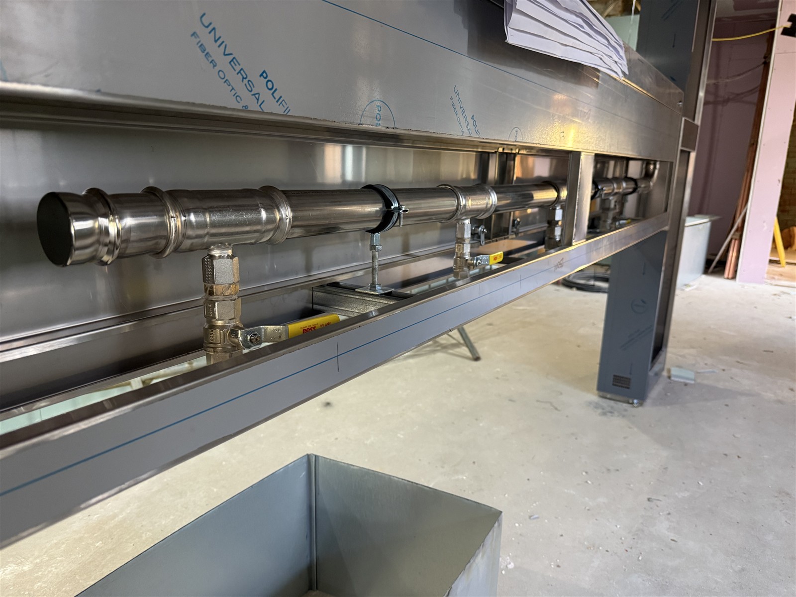 Gas manifold with yellow-handled isolation valves beneath the kitchen structure at Beaconsfield Golf Club