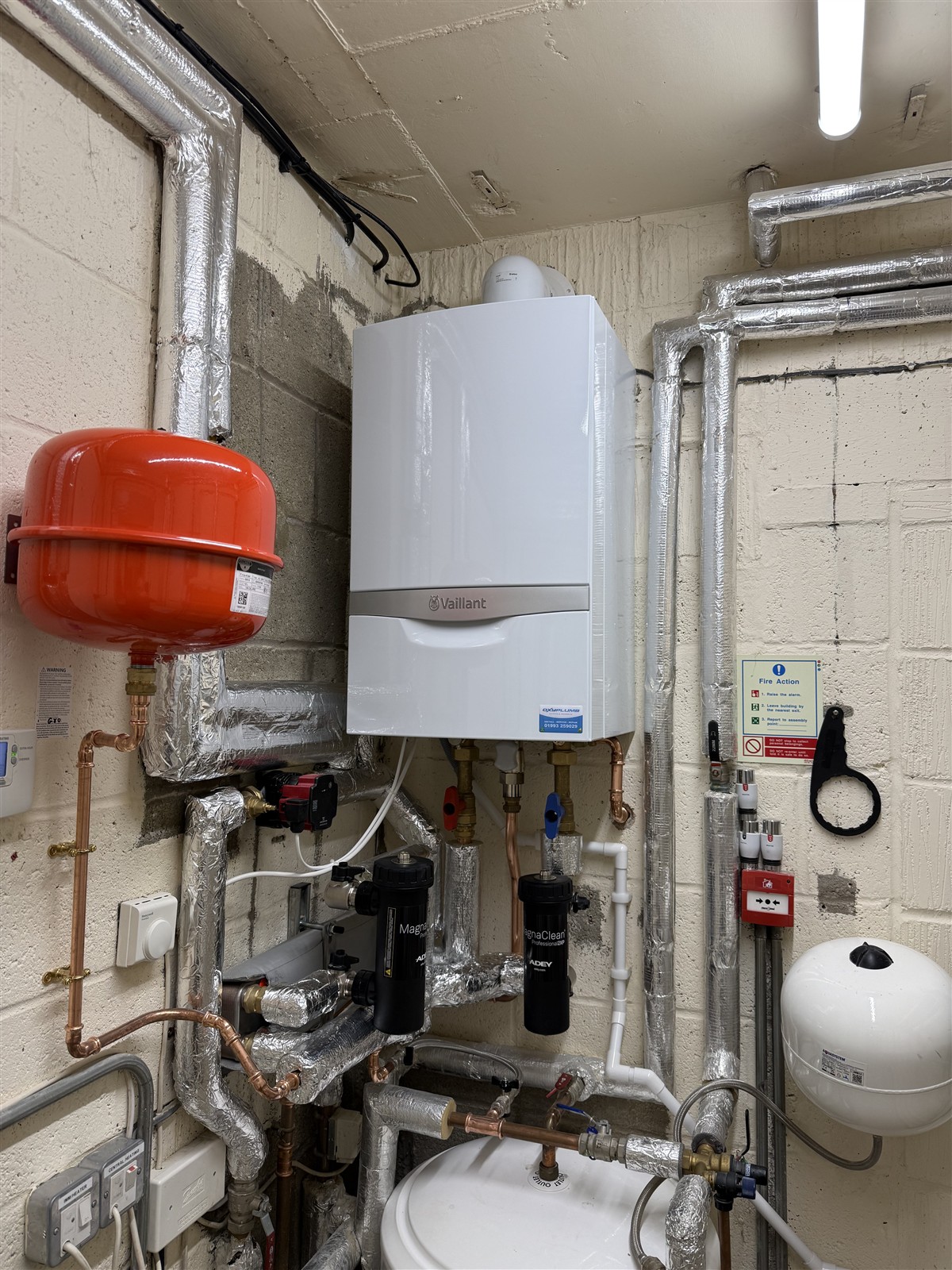 Vaillant boiler with red expansion vessel and connected plant-room pipework at Carterton Community Hall