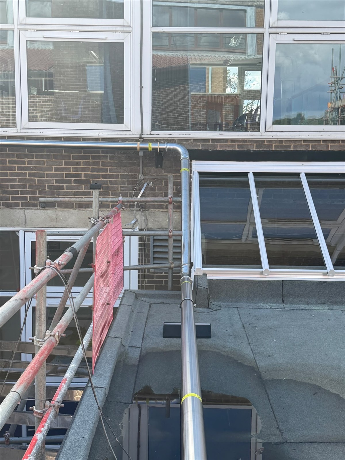 Stainless steel gas pipe rising beside the classroom windows at Faringdon Community College