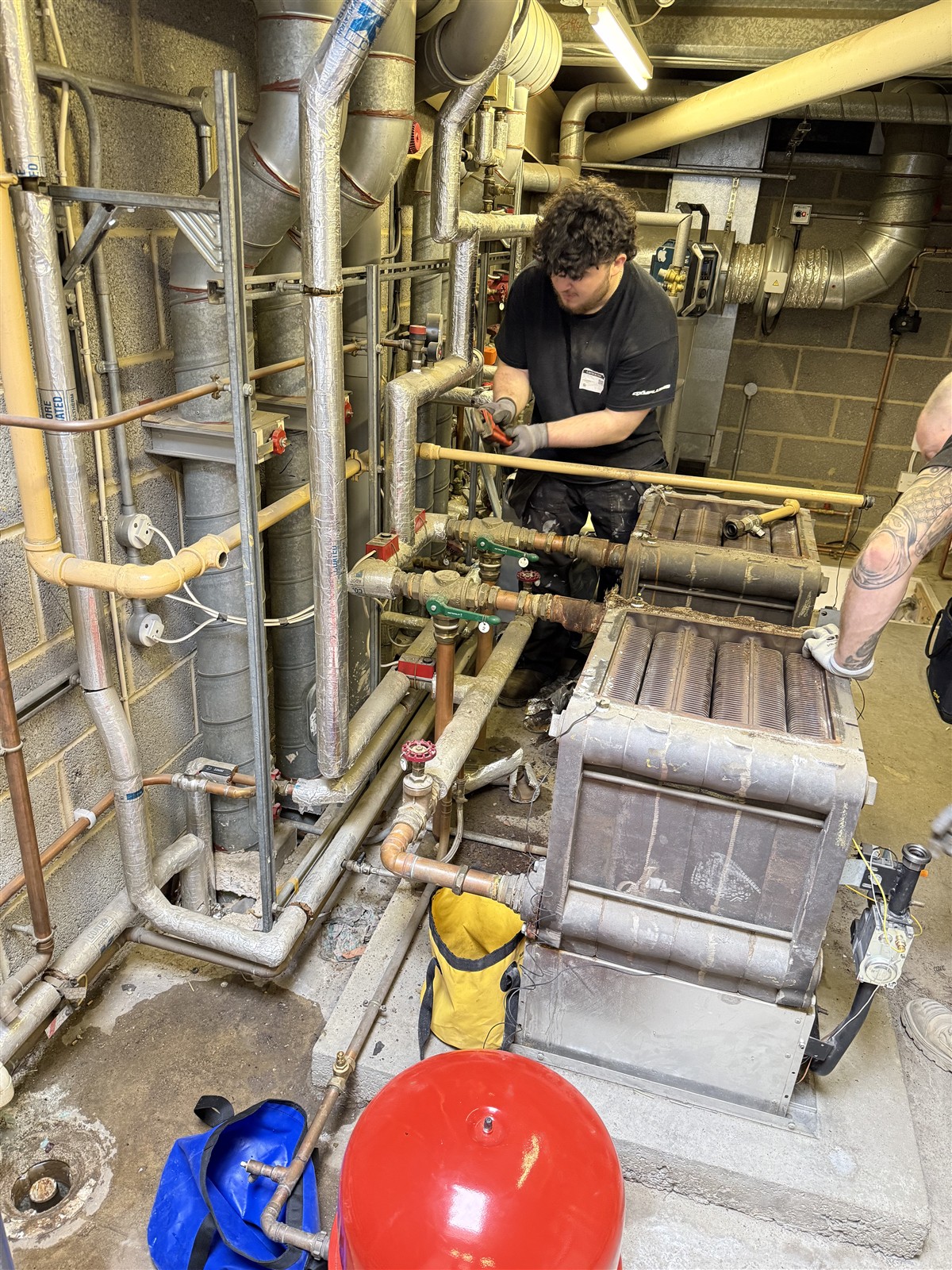 Engineer altering existing plant-room pipework at LTI Metaltech
